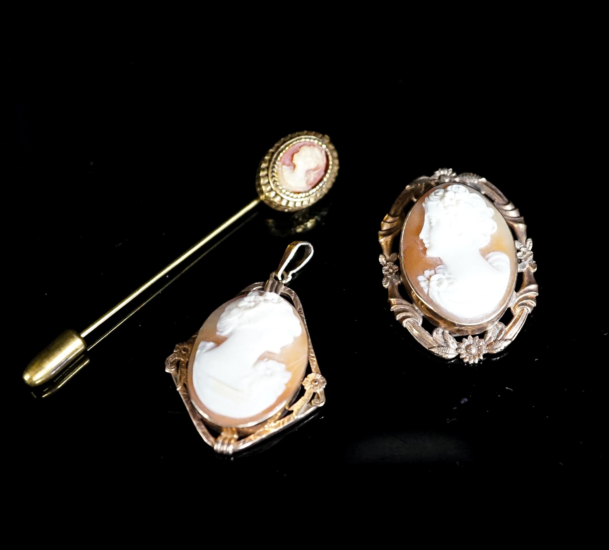 Two mounted cameo shell pendants, one with brooch attachment and a gilt metal cameo pin.